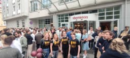 Duża grupa uczestników gry miejskiej UrbGames przed hotelem